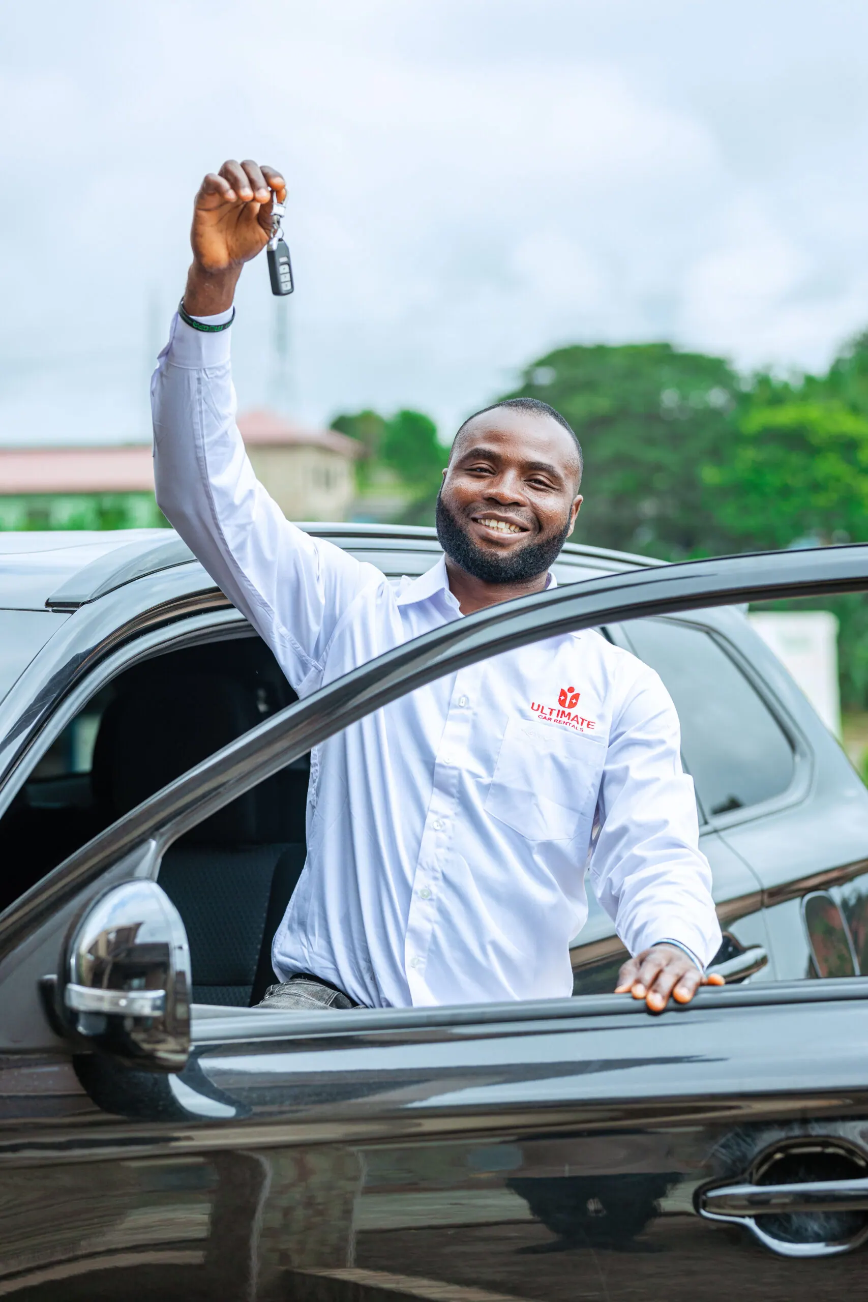 Ultimate Car Rentals team member holding up car keys
