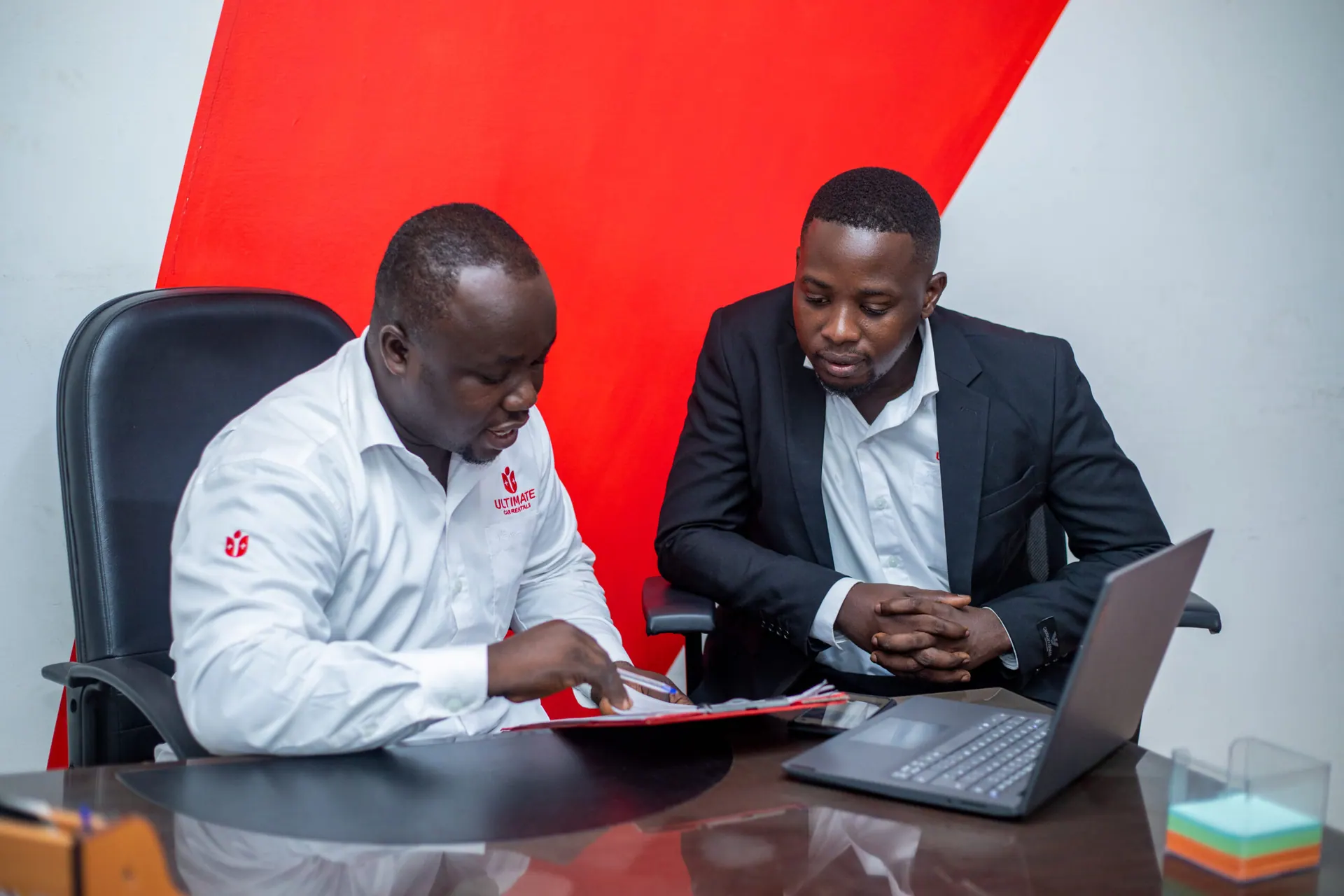 Ultimate Car Rentals staff assisting a client at the Takoradi office